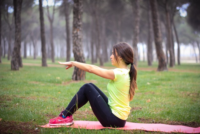 Sentada con piernas flexionadas y brazos extendidos